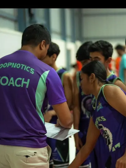 A coach going over the game plan with his team during a timeout. Tactical instruction is a key part of our competitive approach.