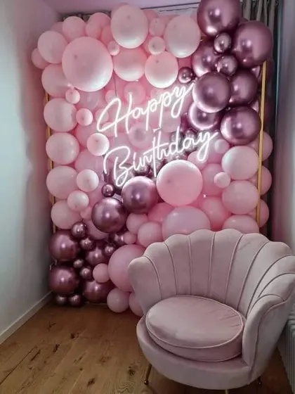 This full balloon wall is a fantastic photo opportunity for a birthday party. Created with shades of pink and metallic rose gold, it features an integrated neon sign and provides a luxurious, immersive backdrop for guests.