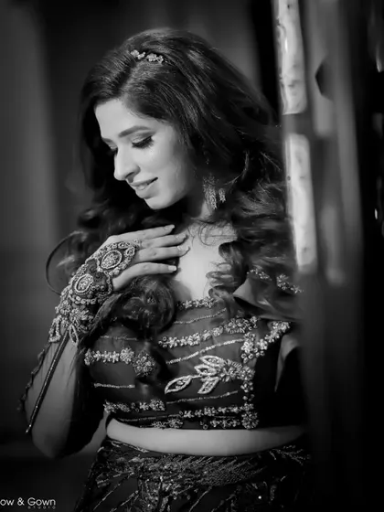 A classic black and white portrait of the bride. This shot highlights the intricate details of her outfit and her serene, happy expression.