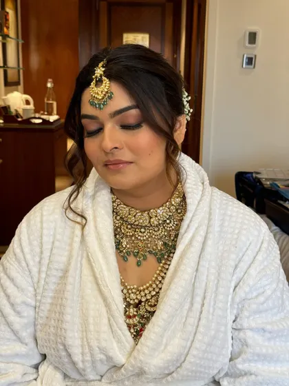 A moment of calm before the ceremony. This close-up on Jinal shows the soft, blended smokey eye and flawless skin prep, creating the perfect canvas for her grand bridal look.
