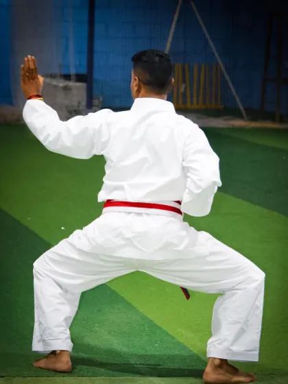 The foundational horse stance (Kiba Dachi) is crucial for stability and power generation. This image shows the strong base required for advanced techniques.