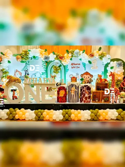 A wide view of Atharva's 'Wild One' celebration. The stage is filled with jungle animals, animal-print pedestals, and a large light-up 'ONE' sign, making it a perfect photo opportunity and a memorable centerpiece for the party.