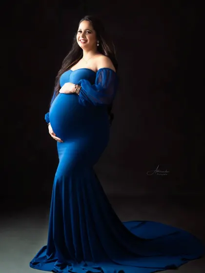 A powerful solo portrait against a dark background. The rich royal blue of the gown stands out, creating a dramatic and elegant fine art photograph.