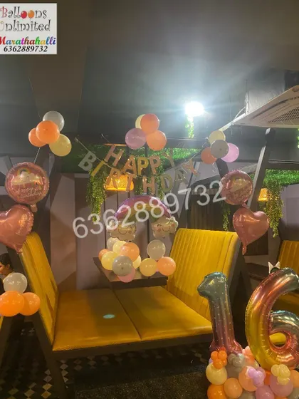 A simple yet beautiful 'Sweet Sixteen' celebration at a cafe, using pastel balloons and a 'Happy Birthday' banner.