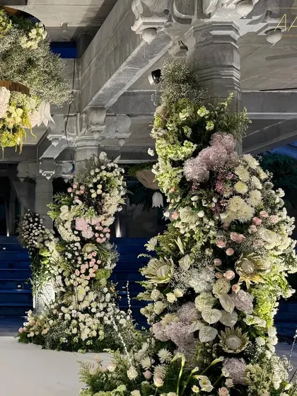 The pillars of the stone mandap at Amita Rasa are wrapped in breathtaking spirals of white and pink flowers. This design blended the natural beauty of the venue with soft, romantic floral artistry.