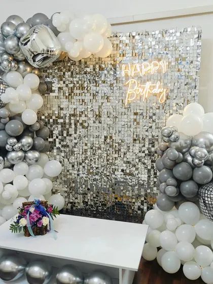 A close-up of our disco-themed birthday decor. The silver shimmer wall, combined with grey, white, and chrome balloons, creates a perfect party vibe.