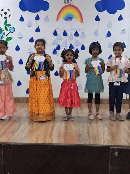 Another group of students on stage, showcasing their handmade rainbows during the celebration.
