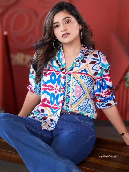 A lifestyle fashion shoot for an actress, featuring a colorful printed shirt and blue jeans. Shot in a modern cafe, these images have a bright, energetic, and youthful feel, perfect for a commercial or social media campaign.