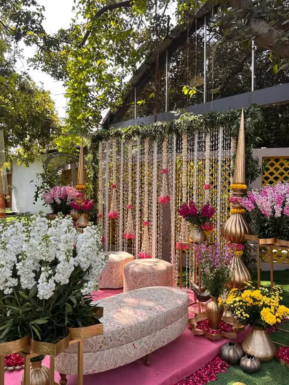 Another angle of the pink mandap, showing the lush floral arrangements and traditional brass spires.