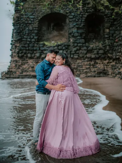 A loving embrace on the beach with waves washing ashore, part of a romantic pre-wedding shoot.