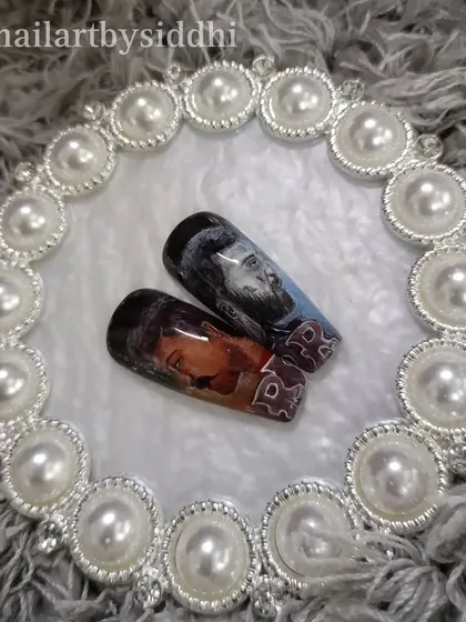 The "RRR" portrait nails displayed on a decorative plate, highlighting them as unique pieces of art.