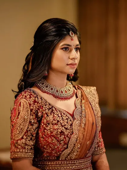 A side profile of Pooja's reception look. The half-up hairstyle keeps the hair away from the face while still looking soft and romantic.