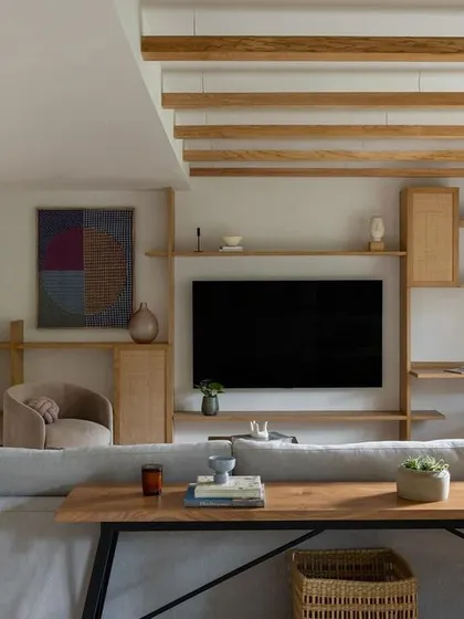 The den in the Tulum House, with its warm wood tones, exposed rafters, and comfortable seating. It's a perfect space for relaxing and watching movies.