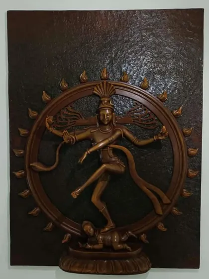 A Natraj mural sculpted in fiber with a classic wood-grain finish. This piece captures the cosmic dance of Lord Shiva, perfect for a space dedicated to art, culture, or spirituality.