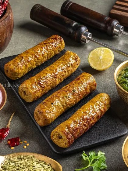 Juicy seekh kebabs on skewers, styled with whole spices and mint chutney to emphasize their aromatic flavors.