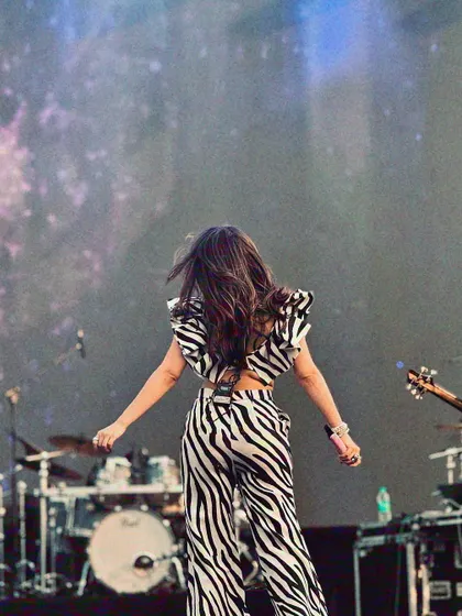 A view from the back, showing the full effect of the zebra-print outfit against the massive stage and lighting rig.