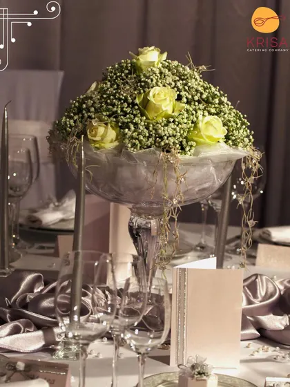 A beautiful floral centerpiece in a glass vase, surrounded by candles and fine glassware. These small details in our table decor contribute to a memorable and aesthetic atmosphere for your event.
