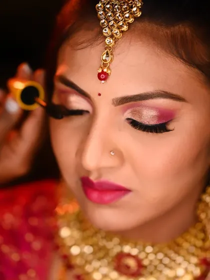 This reception look is all about drama and color. I used a bright pink and gold cut-crease eyeshadow technique with a matching bold lip to create a stunning party look.