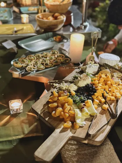 A candlelit grazing board featuring a selection of cheeses, dried apricots, and crackers. It's the perfect start to an elegant evening.
