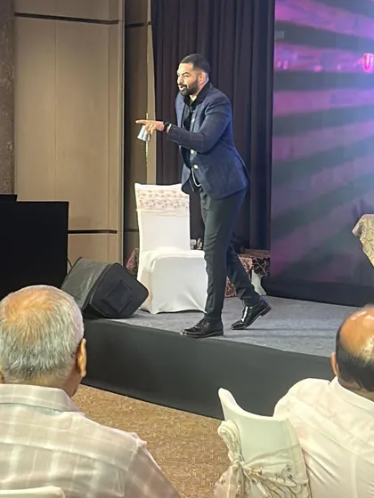 Pointing to a member of the audience to invite them into the performance. Direct interaction is what makes these workshops so effective for team bonding.