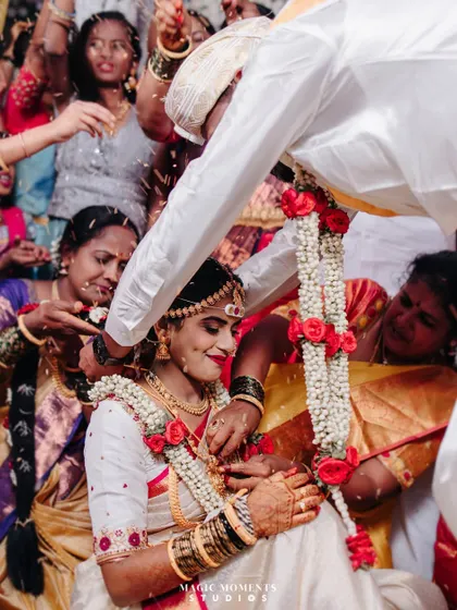 The tying of the mangalsutra, a pinnacle moment of the wedding ceremony, surrounded by the happy faces of family.