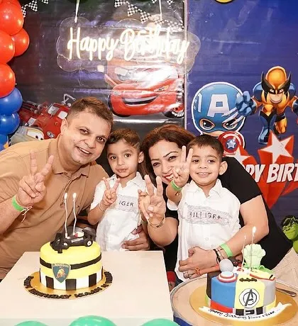 This family is all smiles as they celebrate their twin boys' birthday with a custom car and superhero cake.