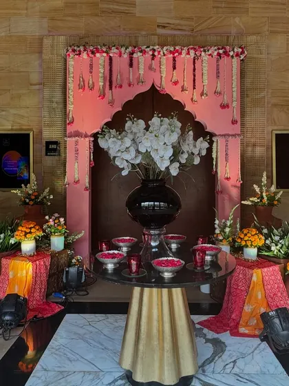 The welcome area for the Bhaat and Tilak ceremony. A traditional archway decorated with floral strings and a beautifully arranged welcome table greet guests as they arrive.