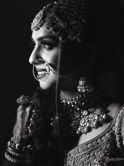 A striking black-and-white profile of the bride, highlighting her features and jewelry.
