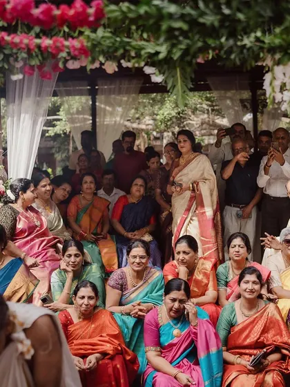 Wedding guests, dressed in colorful sarees, watch the ceremony from the steps of the Kalyani.