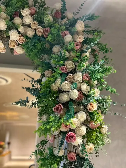 We love how the soft pink and white roses complement the vibrant green foliage in this entrance setup. This combination is perfect for a chic and modern Gruhapravesam decoration theme.
