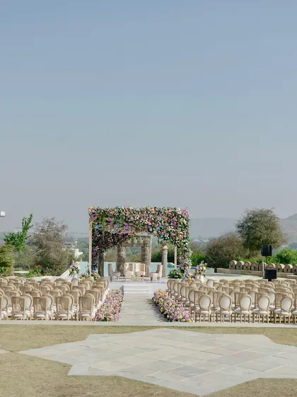 A wide view of the ceremony space before guests arrive, showcasing the clean lines and beautiful landscape of the Udaipur venue. Meticulous planning ensures everything is perfect for the main event.