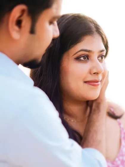 A close-up portrait capturing a tender moment. The soft light and tight framing focus entirely on the couple's emotion and connection.