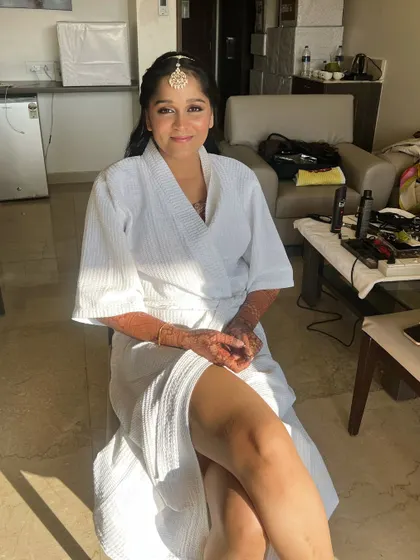 Another shot of the bride getting ready, with sunlight streaming in. The makeup process should be a pampering and enjoyable experience.