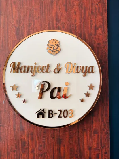 A custom nameplate I designed for a client, featuring acrylic lettering, a Ganesha motif, and a rose-gold finish.