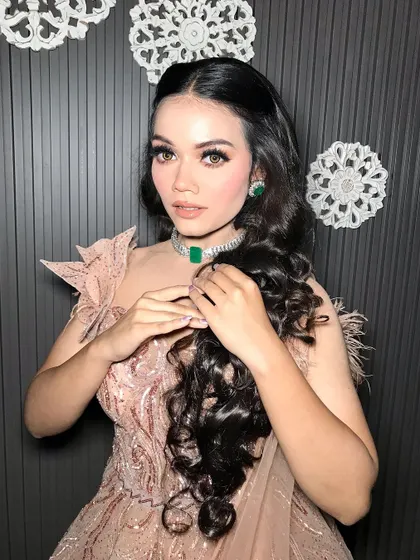 A close-up of the hair and makeup, showing the soft waves and flawless skin.