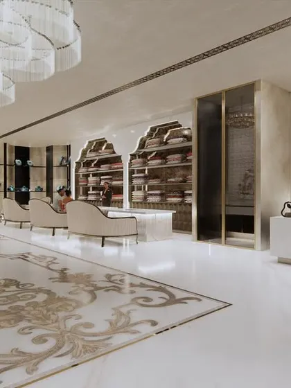 This perspective shows the relationship between the reception desk, the main retail floor, and the staircase. The consistent use of white, gold, and intricate patterns creates a cohesive and opulent interior design for the bridal store.
