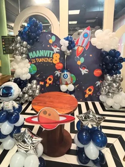 Another perspective of the detailed space theme party, highlighting the custom cake table and balloon sculptures.