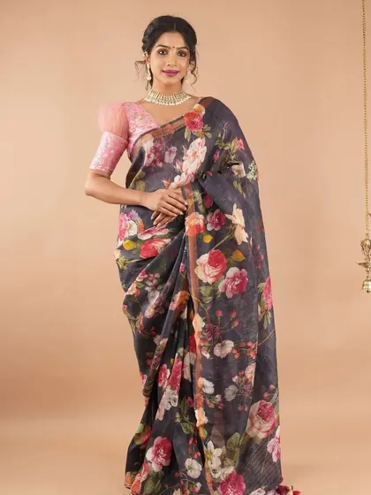 This black linen saree with a vibrant floral print is a modern classic. It’s paired here with a pink puff-sleeve blouse for a chic, contemporary look.