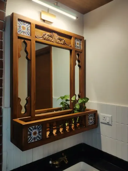 A closer look at the ornate mirror, highlighting the detailed carving at the top, the jharokha-style side panels, and the beautiful ceramic tiles that add a pop of color and pattern.