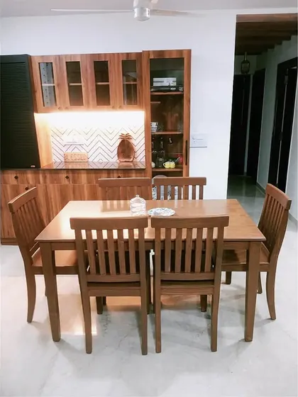 A dining space designed for togetherness. This six-seater wooden dining set was crafted to perfectly match the client's existing crockery unit, creating a warm, cohesive, and homely area for family meals.