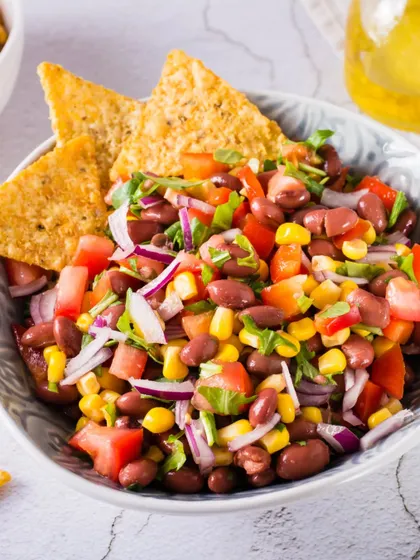 A close-up of the Mexican Cowboy Caviar, a vibrant mix of beans, corn, and fresh vegetables. This is a perfect party salad that's both healthy and delicious.