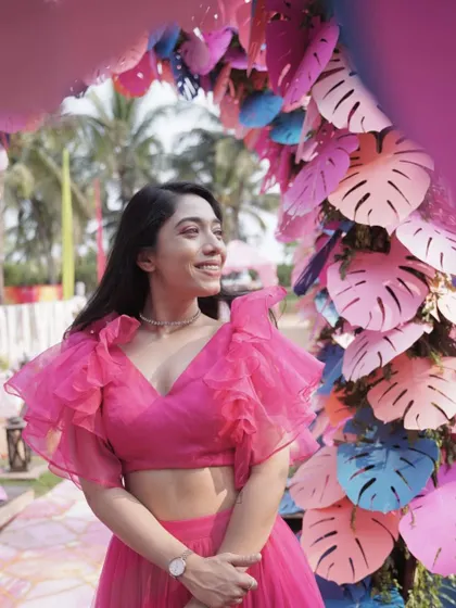 A beautiful pink ruffled outfit against a stunning floral backdrop. This look is perfect for a daytime Mehendi or a bachelorette party.