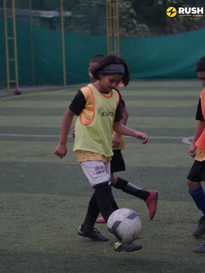 A young girl dribbles with determination during a practice game.