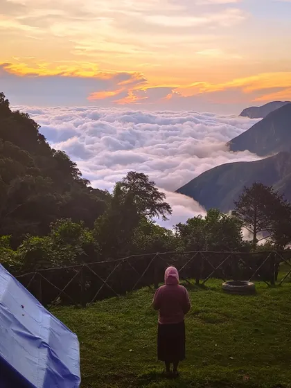 A trekker enjoying the sunrise from the campsite, a perfect start to the day.