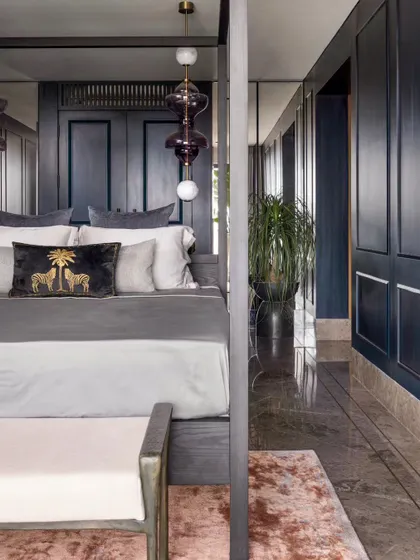 A side view of the master suite in our Bengaluru high-rise project. The deep blue paneled walls wrap around the room, creating a cocoon-like effect, while the polished marble floor adds a touch of glamour.