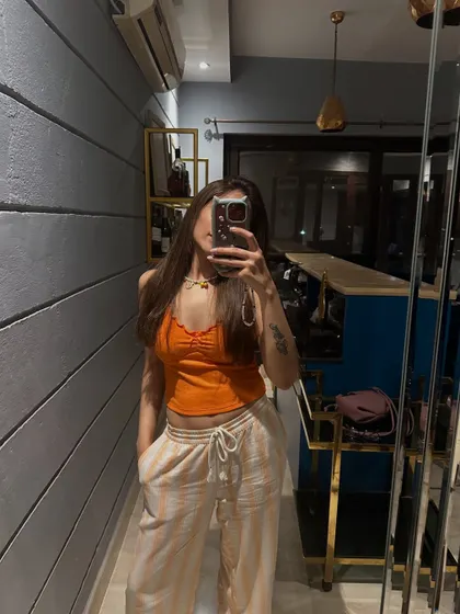 A mirror selfie in a casual orange top and printed pants, part of my "life lately" series.