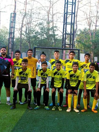 The senior team stands with their coaches, a testament to years of hard work and development within the academy.
