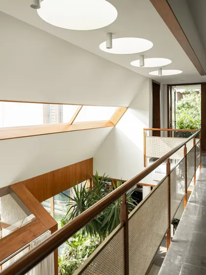 These images show the upper-level bridge and hallway, illuminated by both angled and circular skylights. The combination of different light sources ensures the core of the home is always bright and connected to the time of day.
