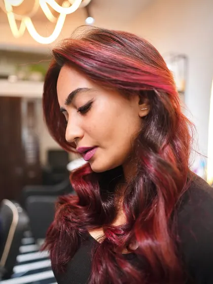 A side profile of the finished red hair look. The layers and waves add so much movement, making the color look dynamic and alive.
