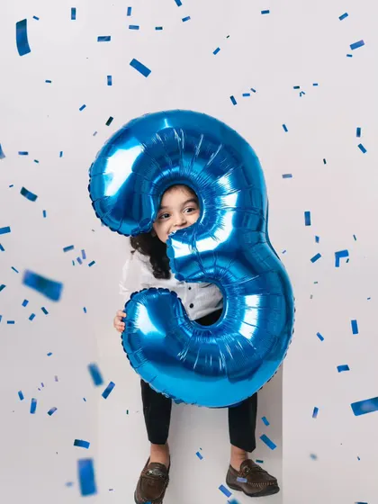 A dynamic shot with confetti. Even in a minimalist studio, we can add elements of fun and action to create exciting birthday photos.